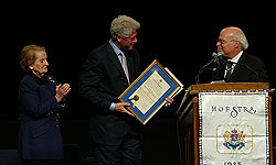 Former U.S. Secretary of State Madeleine Albright watches as former U.S. President Bill Clinton accepts an honorary degree from Hofstra University President Stuart Rabinowitz, following Clinton's address