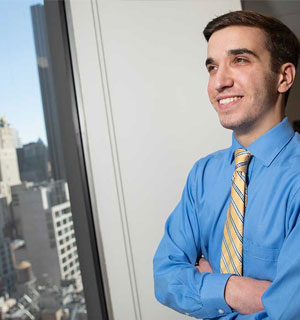 Proud male student looking at NYC from a skycraper window