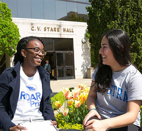 Two students chatting outside on campus