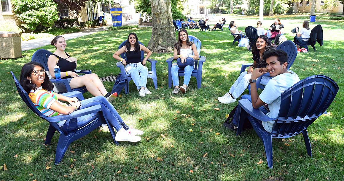 Smiling students on campus lawn