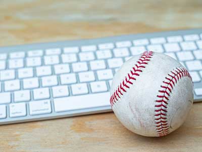 Baseball in front of computer keyboard