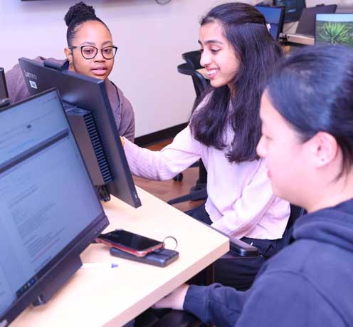 Female students interacting in front of computer