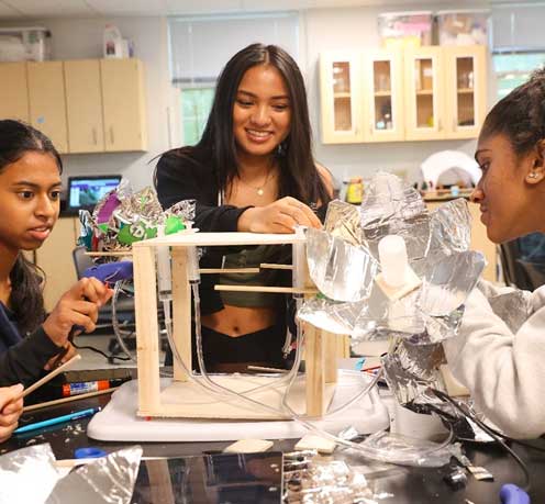 Female students working on a group project in a lab