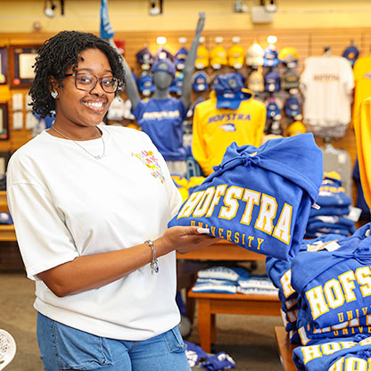 Smiling student carrying Hofstra Tshirt