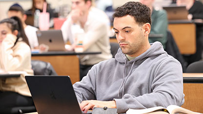 Male student using laptop
